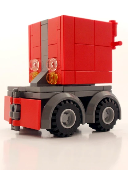 a large red toy truck on white surface