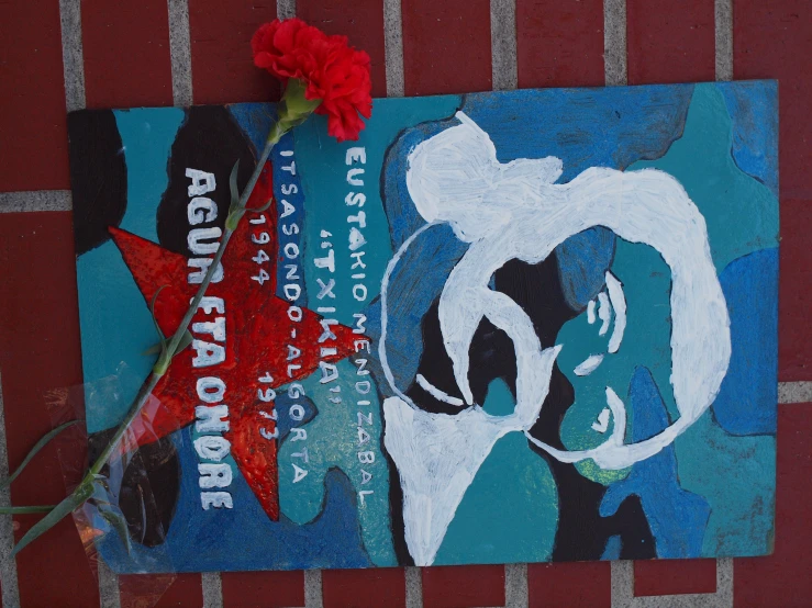 a poster has been placed near a red rose