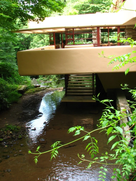 a covered covered bridge on the side of a small creek