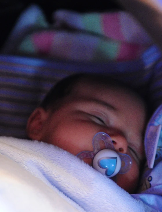 a baby sleeping with a pacifier in his mouth