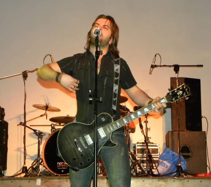 a man singing into a microphone on a stage