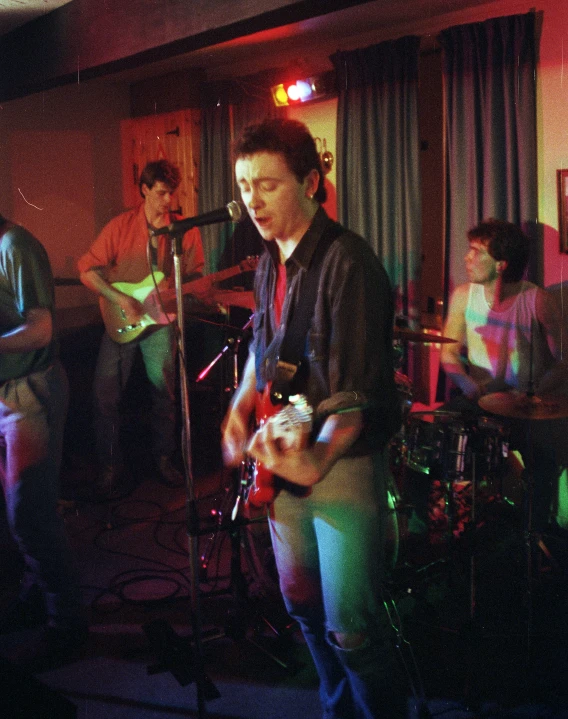 a group of people standing around playing guitars