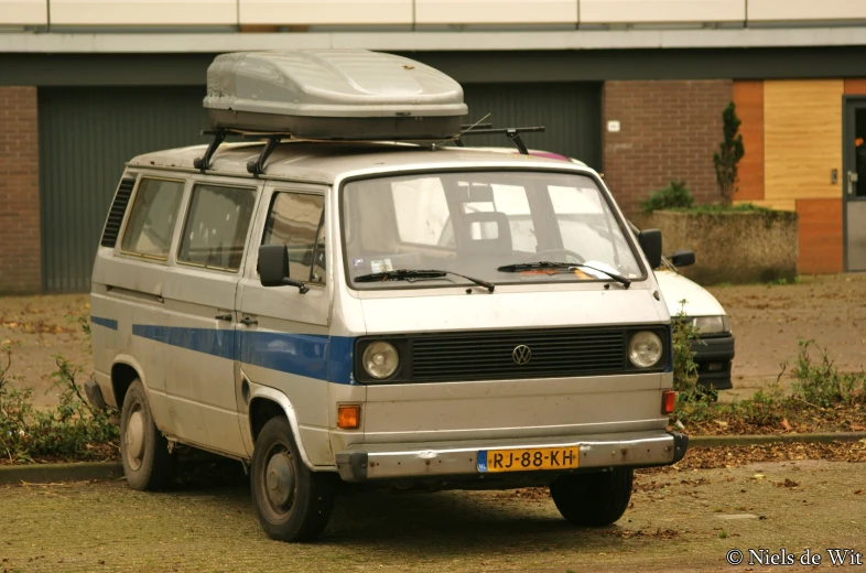a van is with an open roof parked outside a building