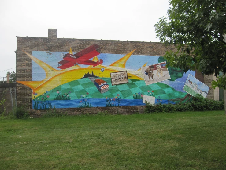 a mural on the side of a building next to green grass
