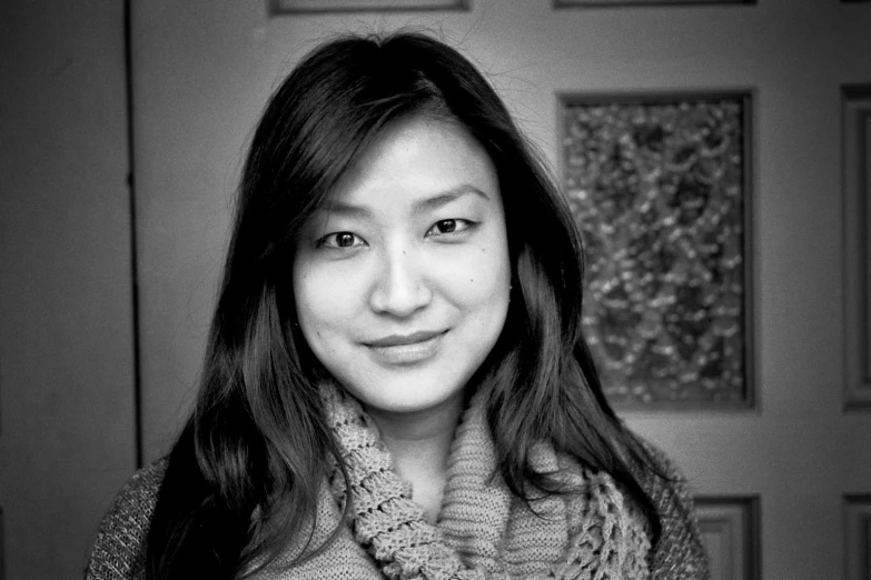 black and white image of an asian woman wearing a knitted scarf