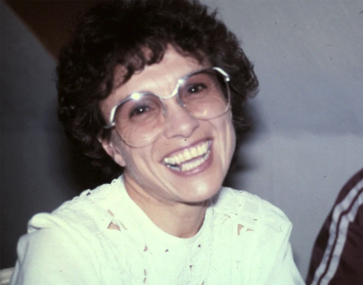 the woman is smiling wearing clear glasses