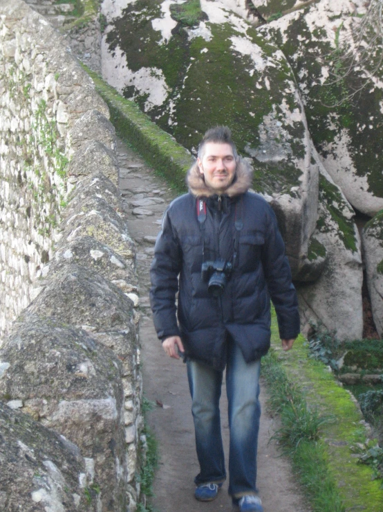 man walking up a stone wall in a park