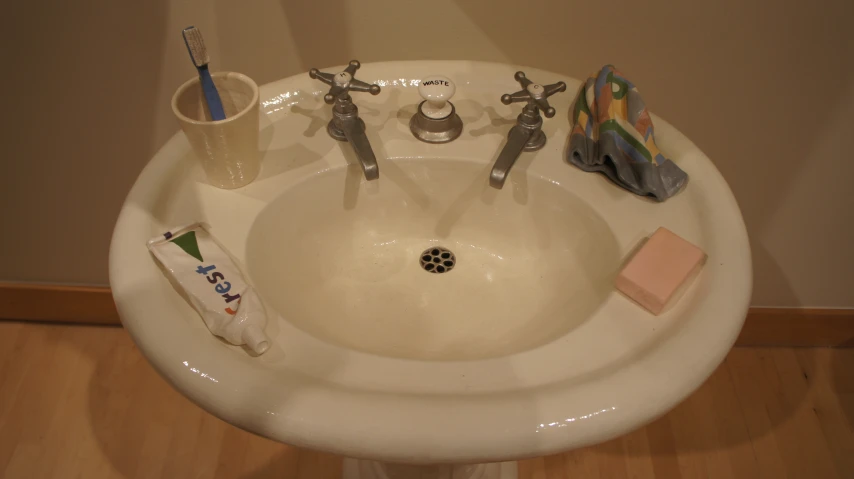 sink on wooden floor with soap and toothbrush