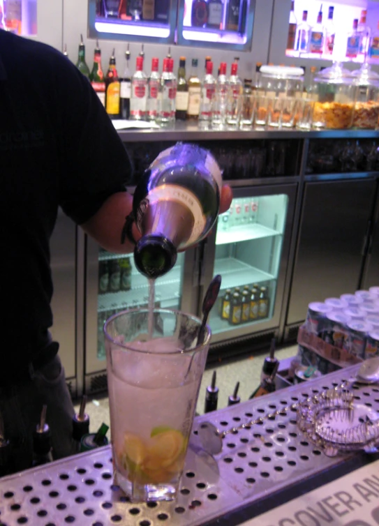 a man is making a drink at a bar