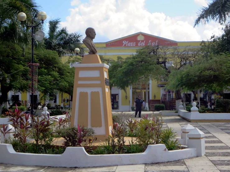 the statue is sitting outside near some plants