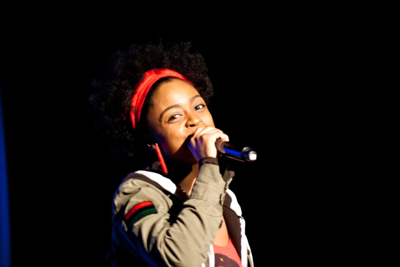 a woman wearing a pair of ear muffs holds a microphone