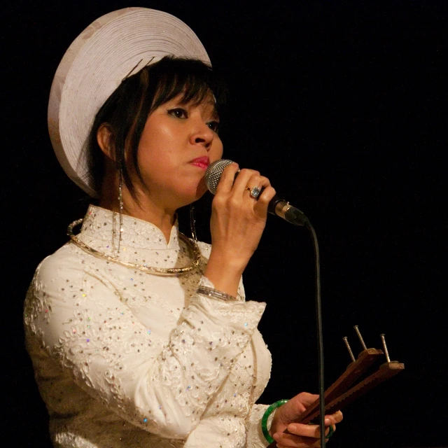 a woman that is holding a microphone and singing