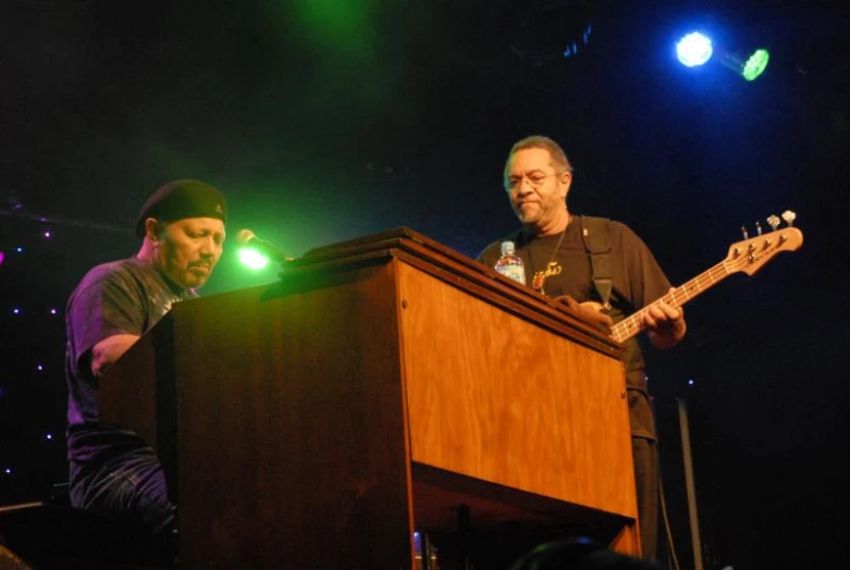 a man playing an electric guitar next to a soundboard