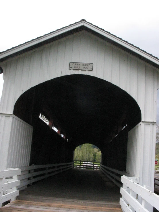 a wooden road going through a covered covered bridge