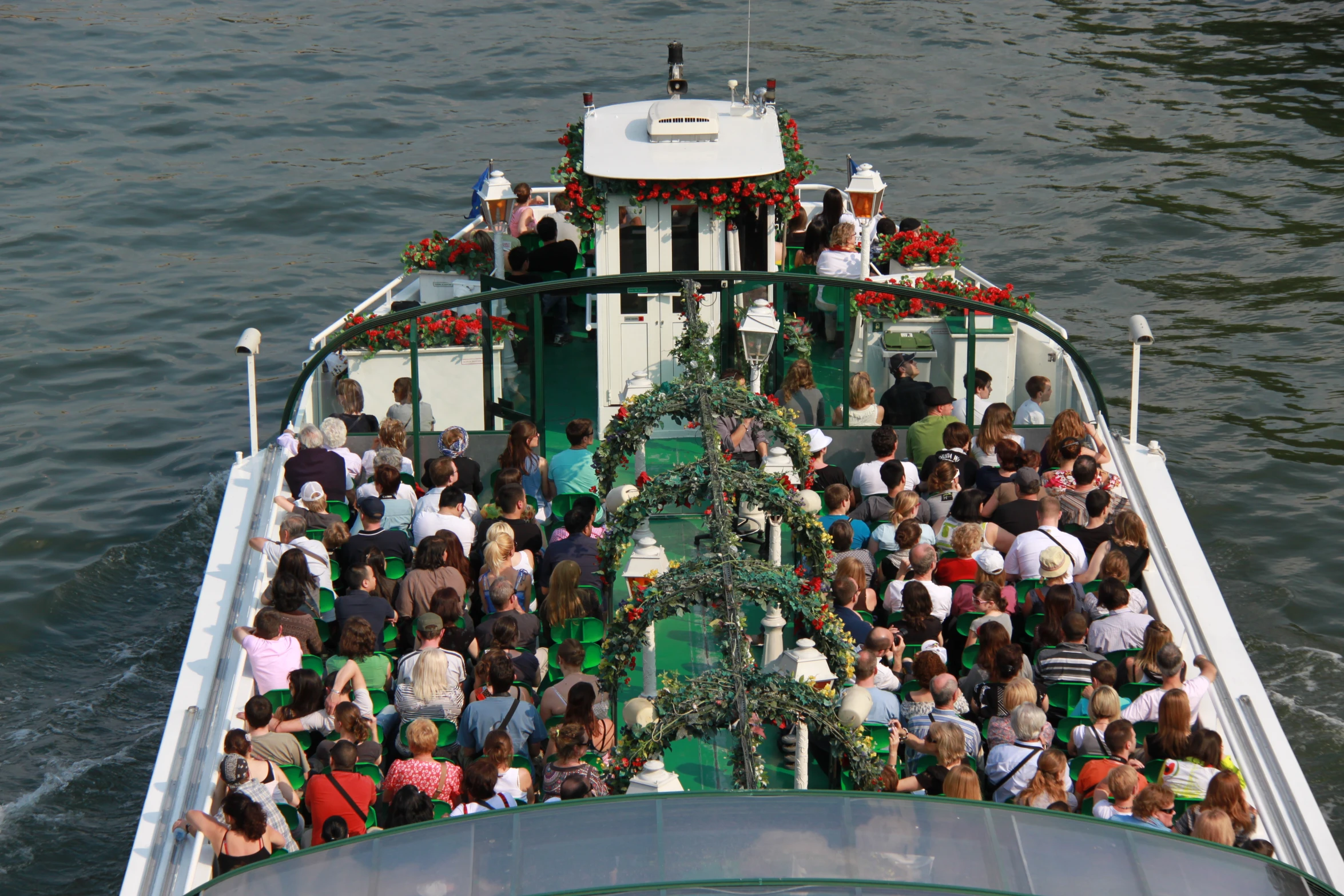 a boat filled with lots of people next to a christmas tree