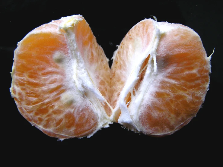 two halves of an orange that are orange cut in half