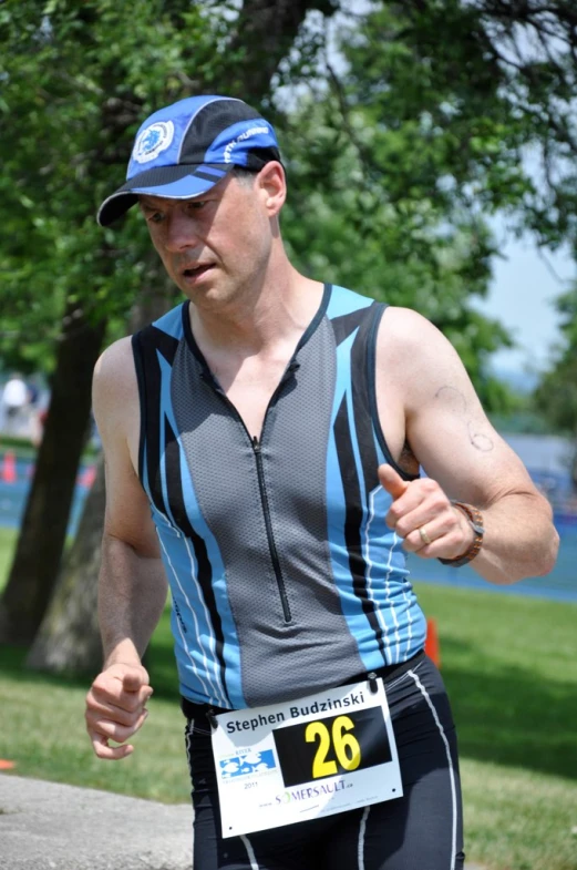 a person in an open shirt running with a sign on his vest