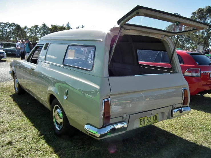 an antique car sits on a show display at the park