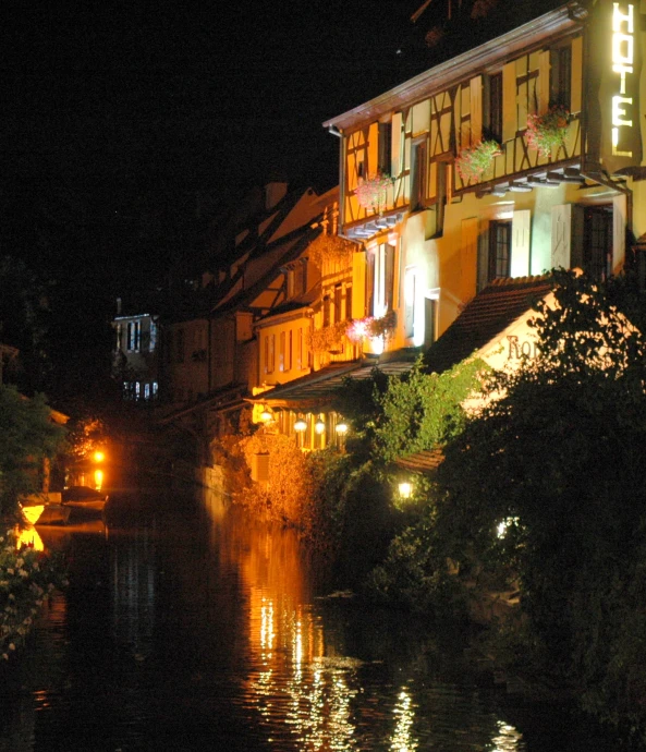 night scene of buildings along the river with lights on