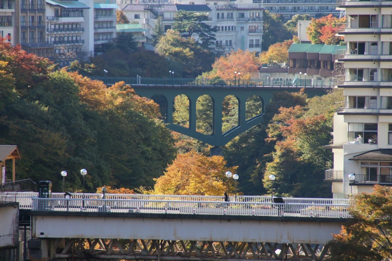 the top view of a bridge over the river with a large city in the background