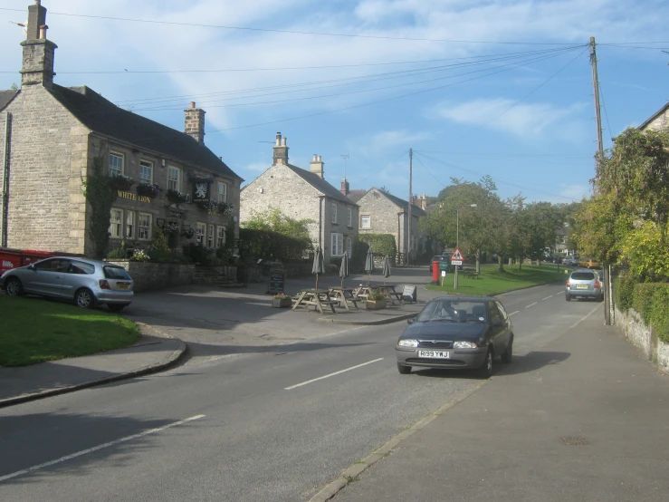 a car is driving down a road between two houses