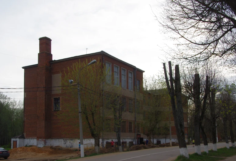 an old, red brick building has a tall chimney