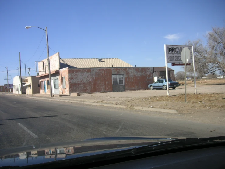 an old brick building sitting by the side of a road