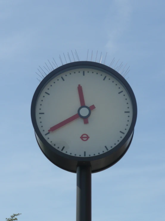 a clock on a pole with some air in the background