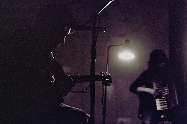 a person plays an accordion at night in a dark room