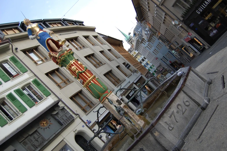 a statue is on a building with buildings in the background