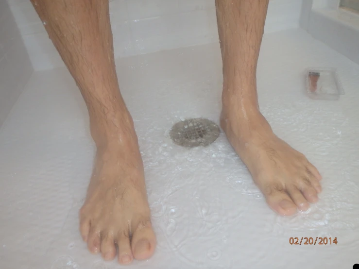 a close up of someone's feet in a bathtub with bubbles and a sponge