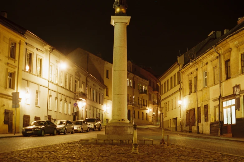 an old stone pillar in the center of a city street