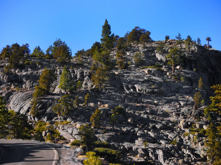 the view from an empty paved road showing a mountain