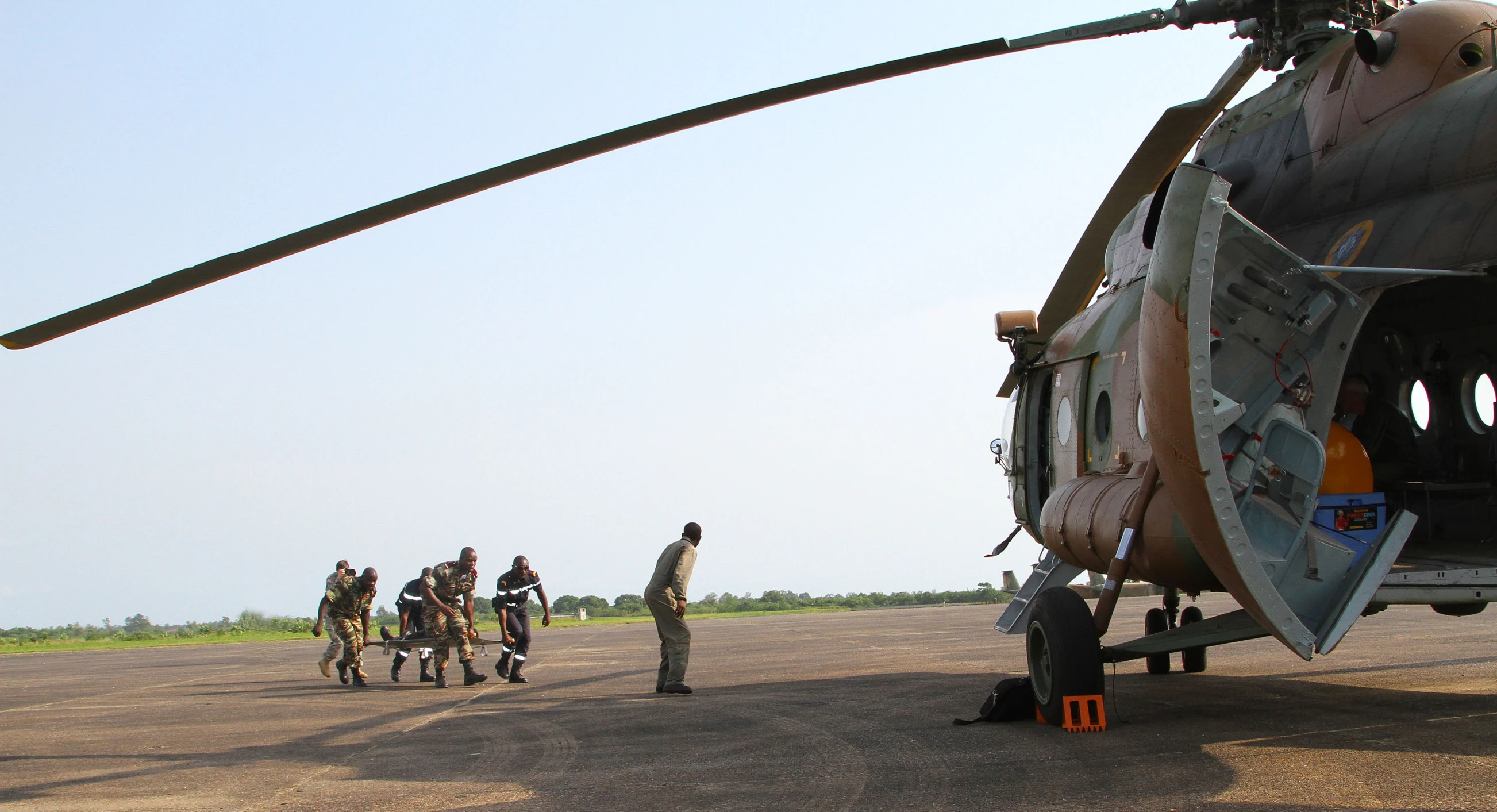 a helicopter with four people standing around it