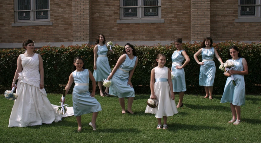 a group of bridesmaids in different colors standing on the grass