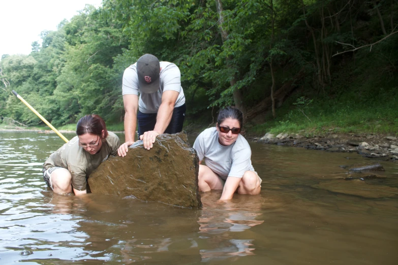 two people digging into soing in the water