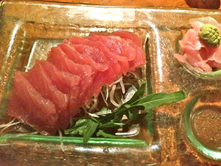 a tray topped with sliced up sashi on a wooden table