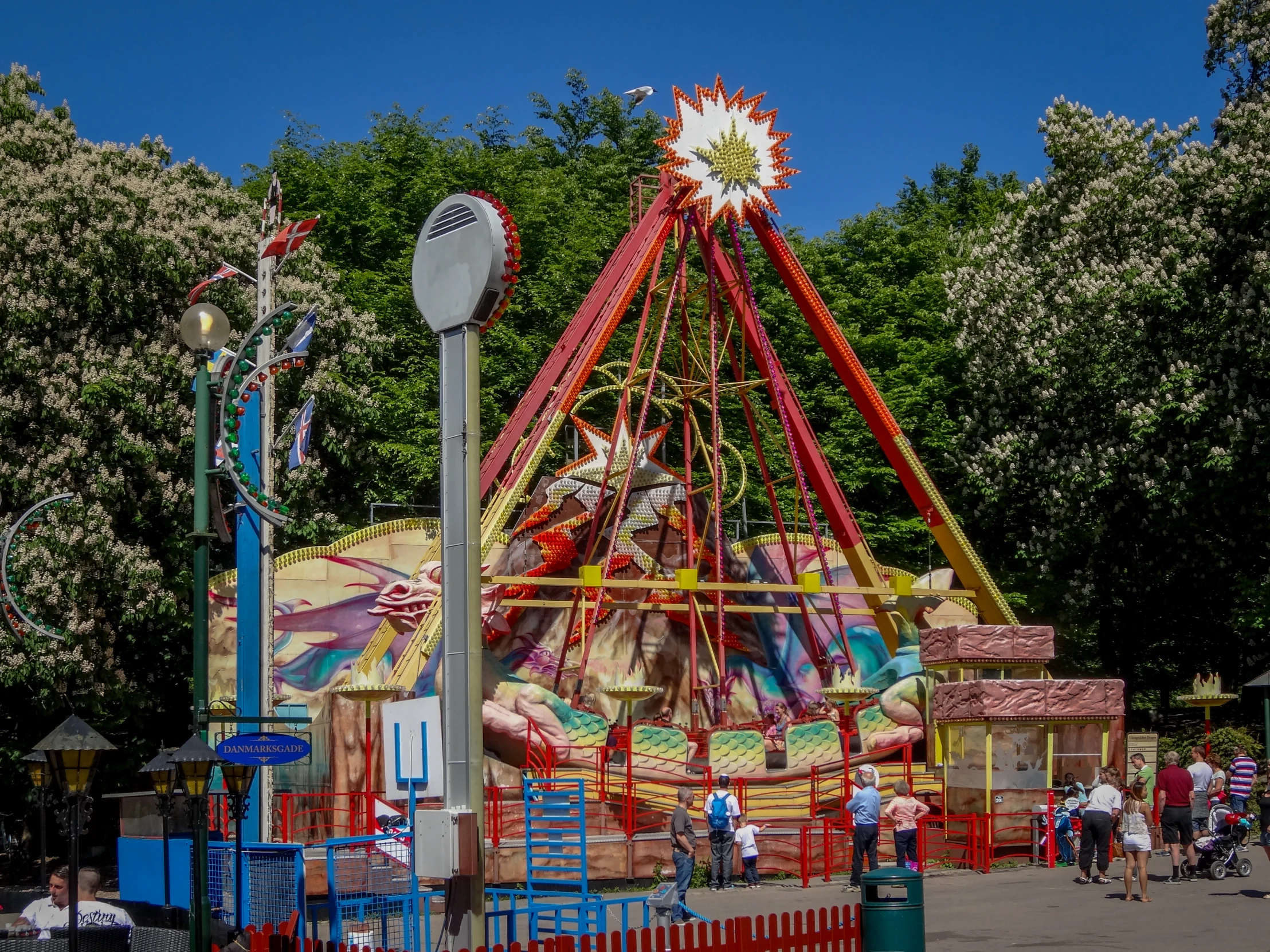 a carnival ride at a park with trees in the background