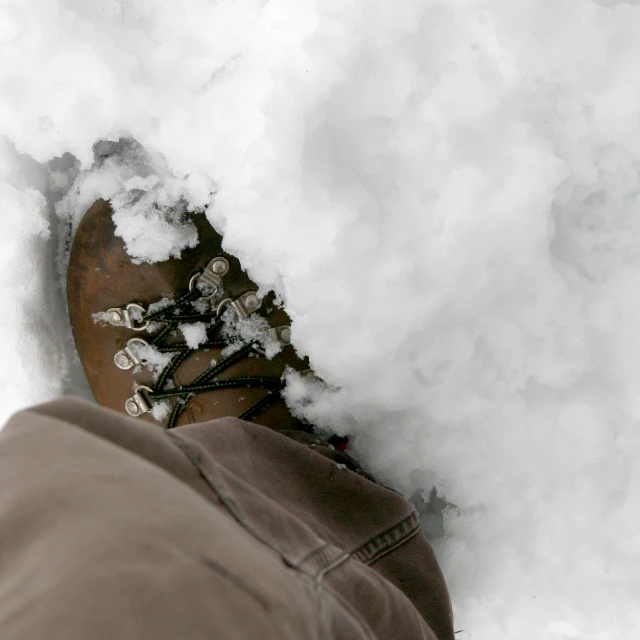the snow has begun to pile up against this person's feet