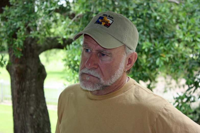 an old man wearing a hat looking to the left