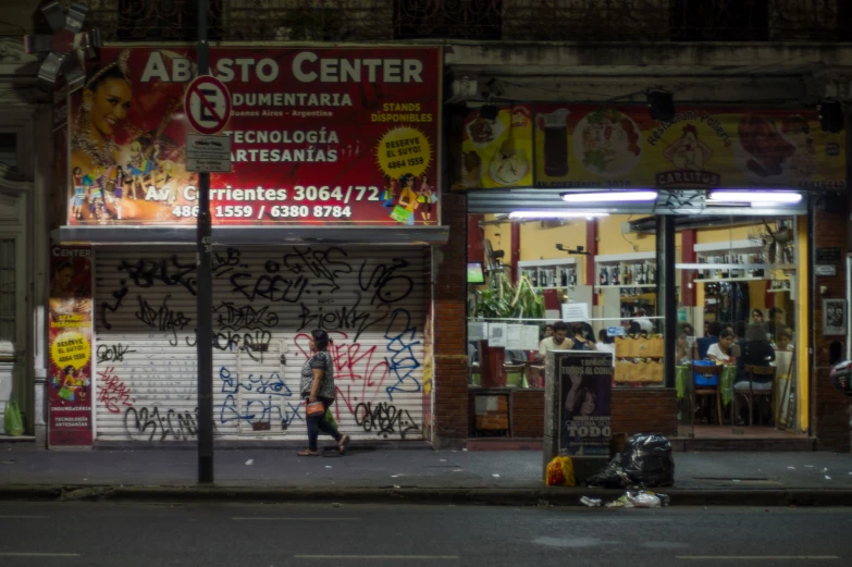 a woman is walking past a wall with graffiti