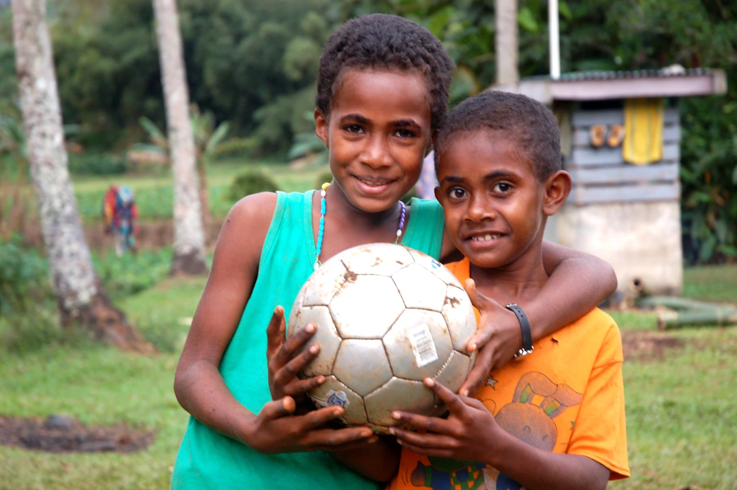 two girls who are holding a soccer ball