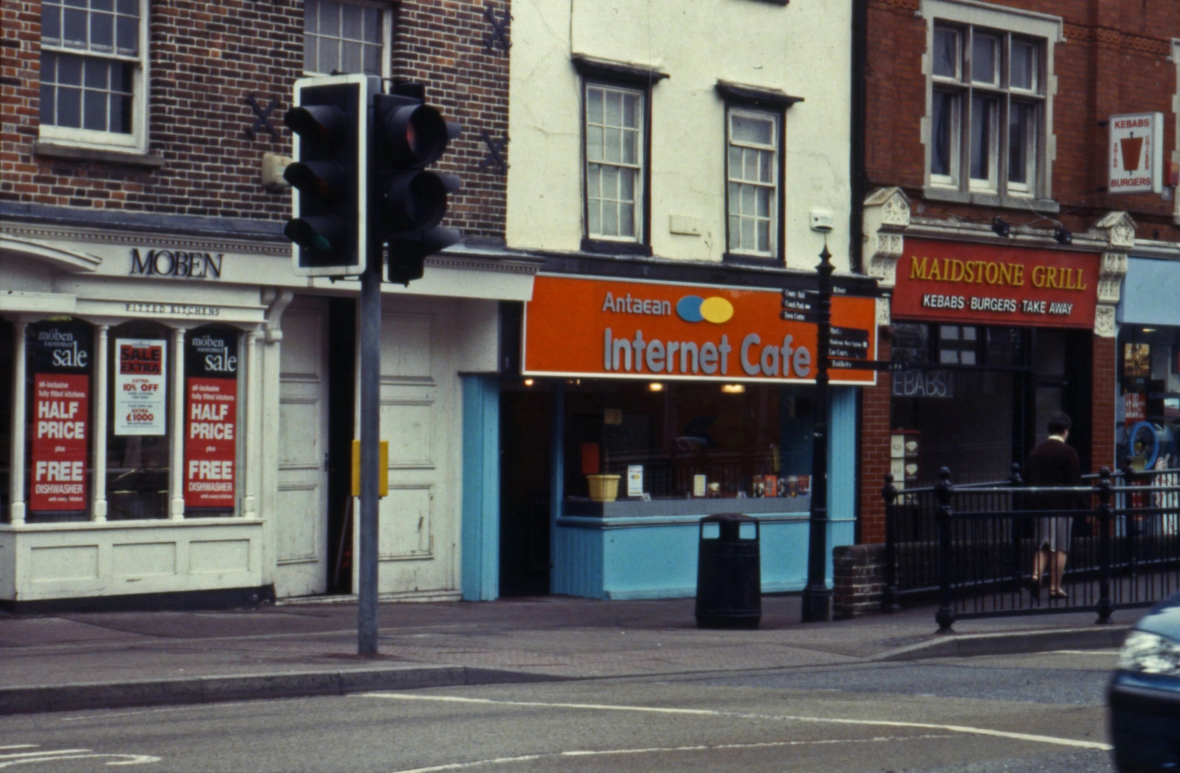 a small building on a corner with various stores