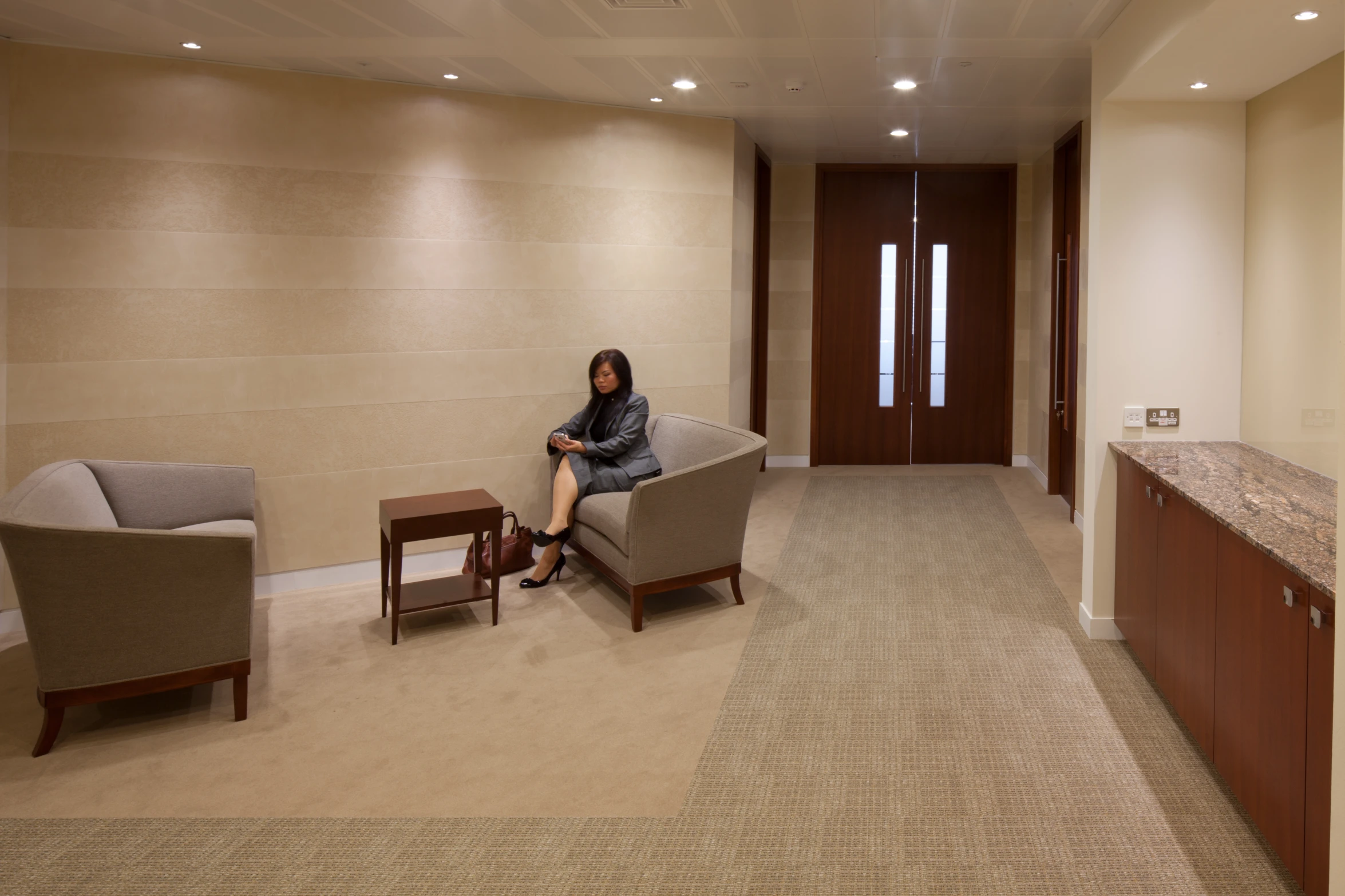 a woman is sitting in a chair by a counter