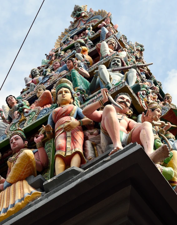 some statues are on the roof of a tall structure