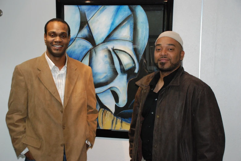 two men in front of an abstract painting and painting