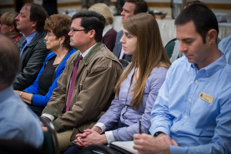 a large group of people are seated next to each other