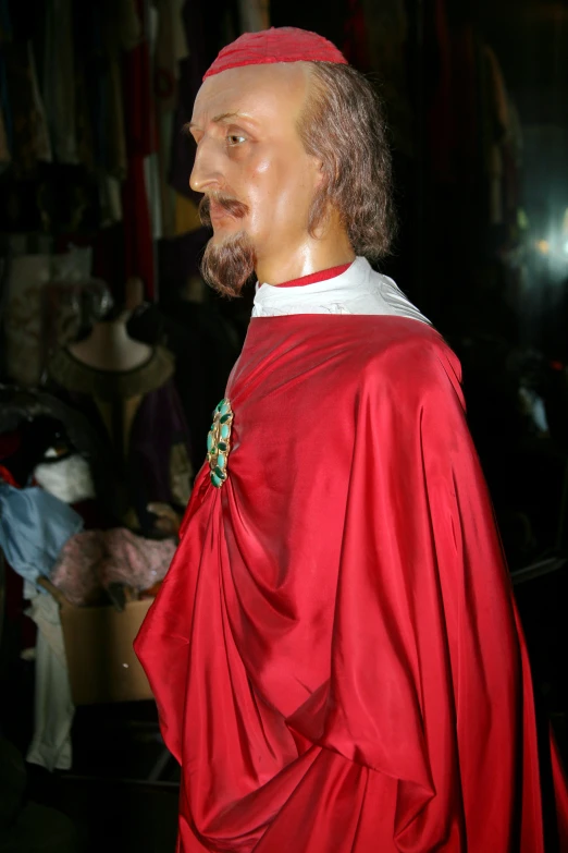 a close up of a fake man wearing a red cloak