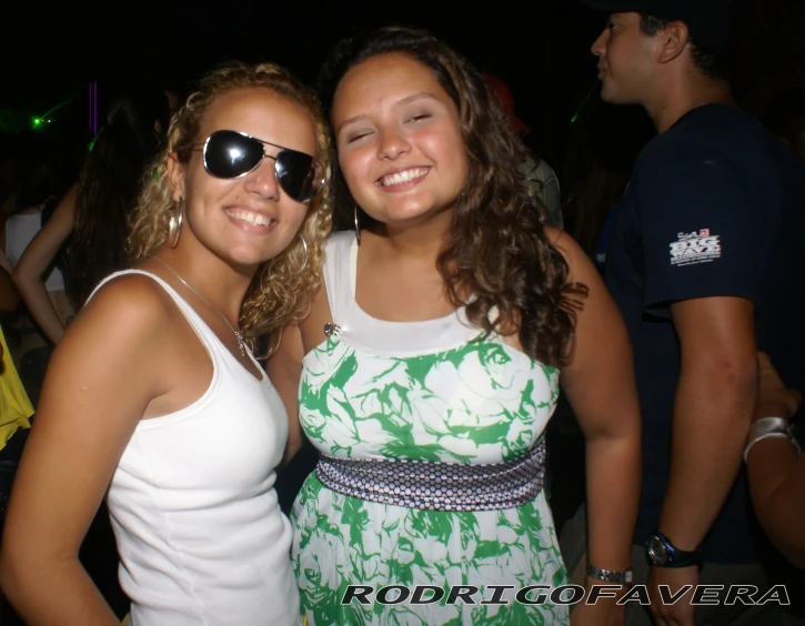 two ladies posing for the camera at a party