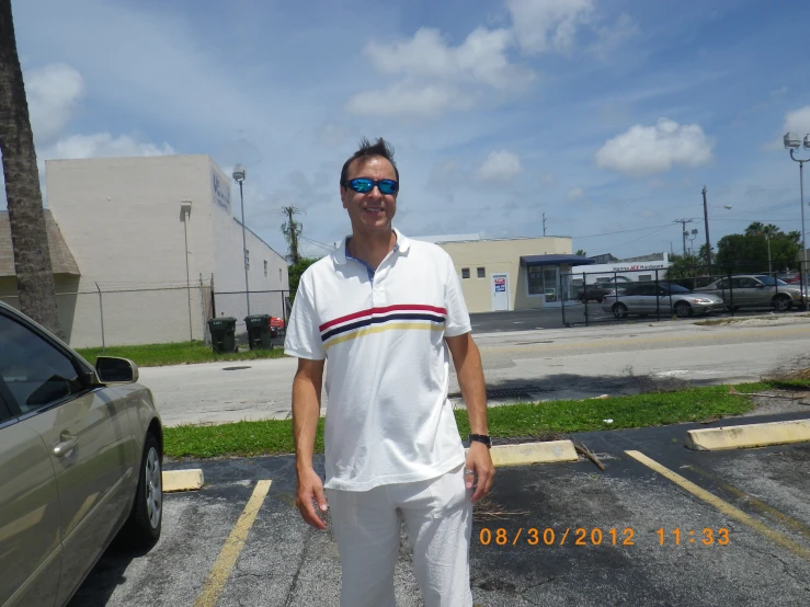 a man in white shorts stands in a parking lot